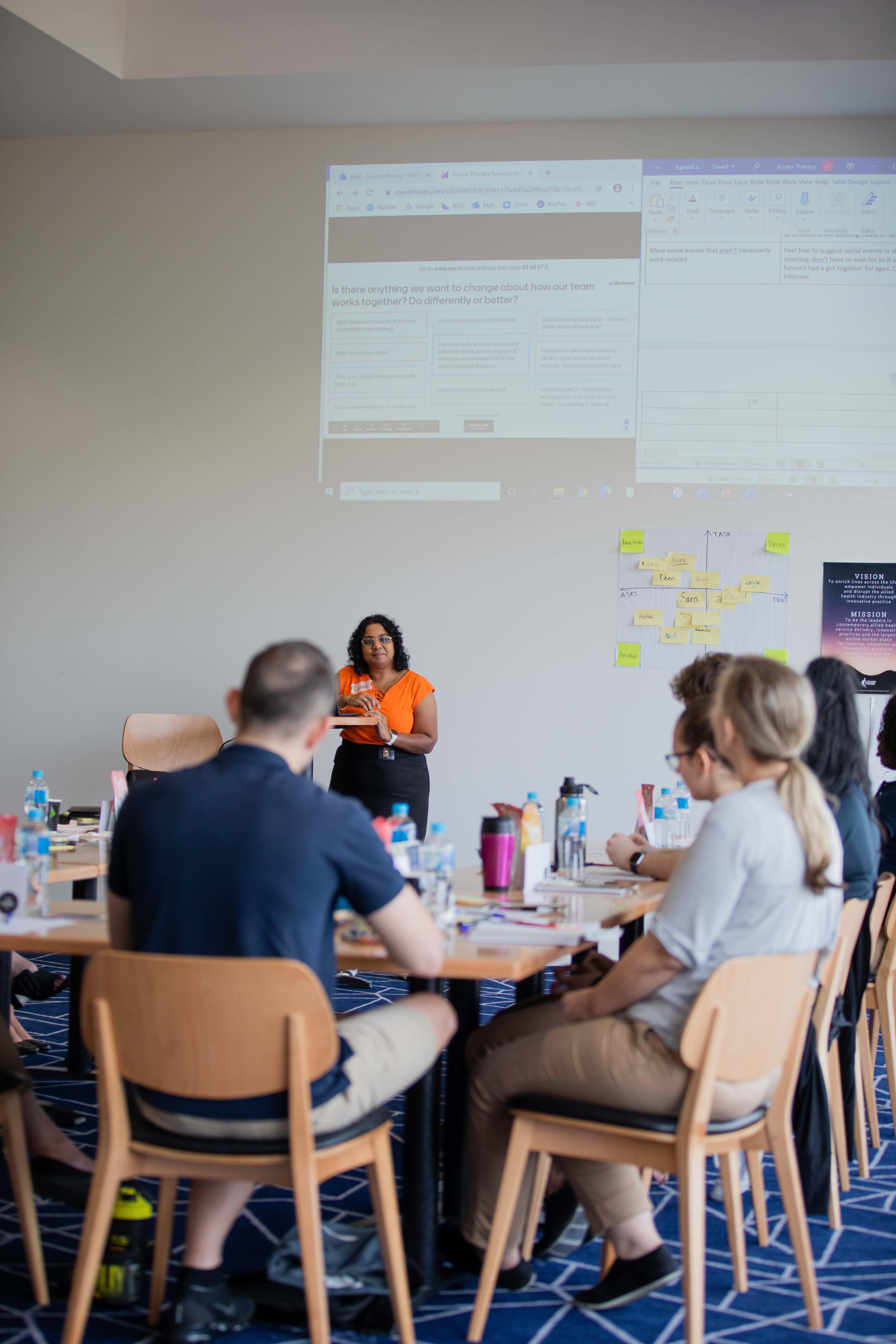 Staff members sit at a table during a team reconnection session facilitated by Renee Madsen Townsville